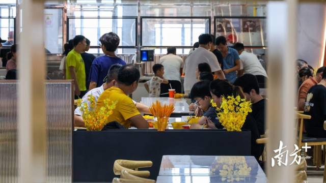 来报到的学生、家长在食堂用餐。
